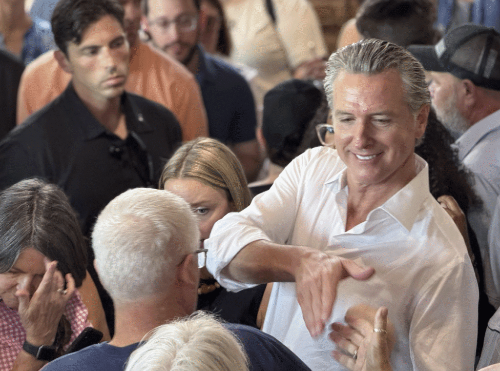California Gov. Gavin Newsom shakes an attendee's hand during a visit to an event center in Pickens, South Carolina
